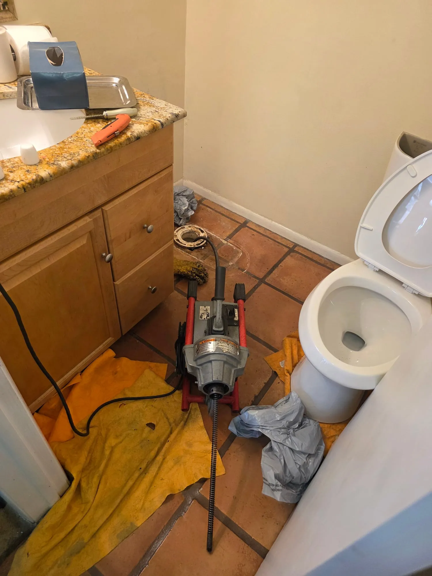 Drain cleaning machine set up in a home bathroom