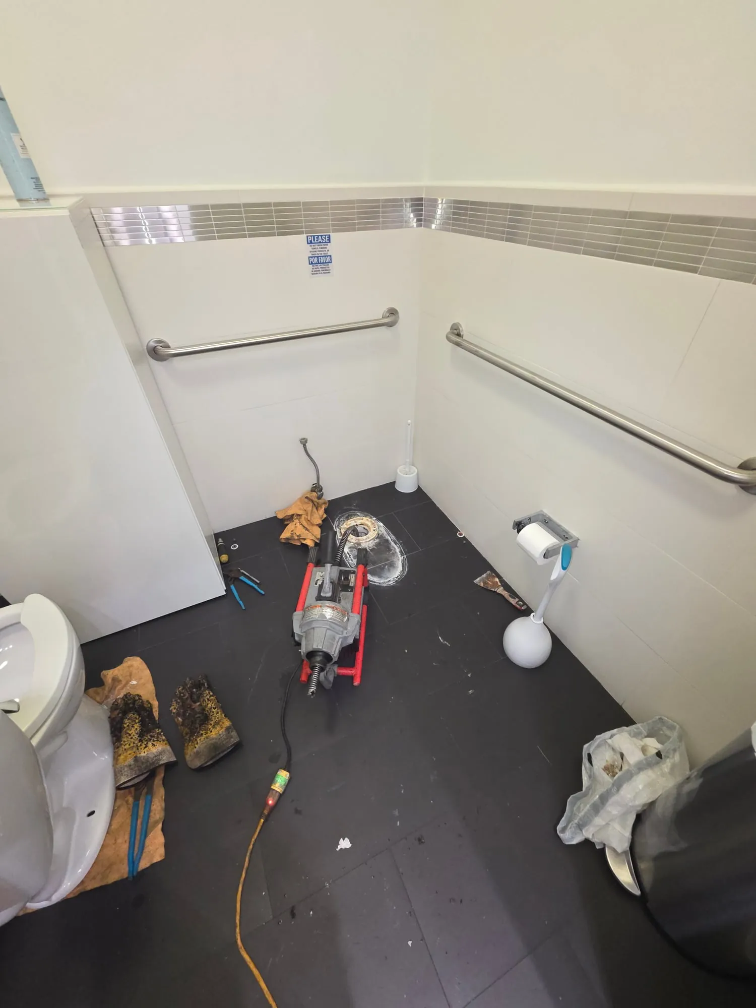 Drain machine at a floor drain in a commercial restroom