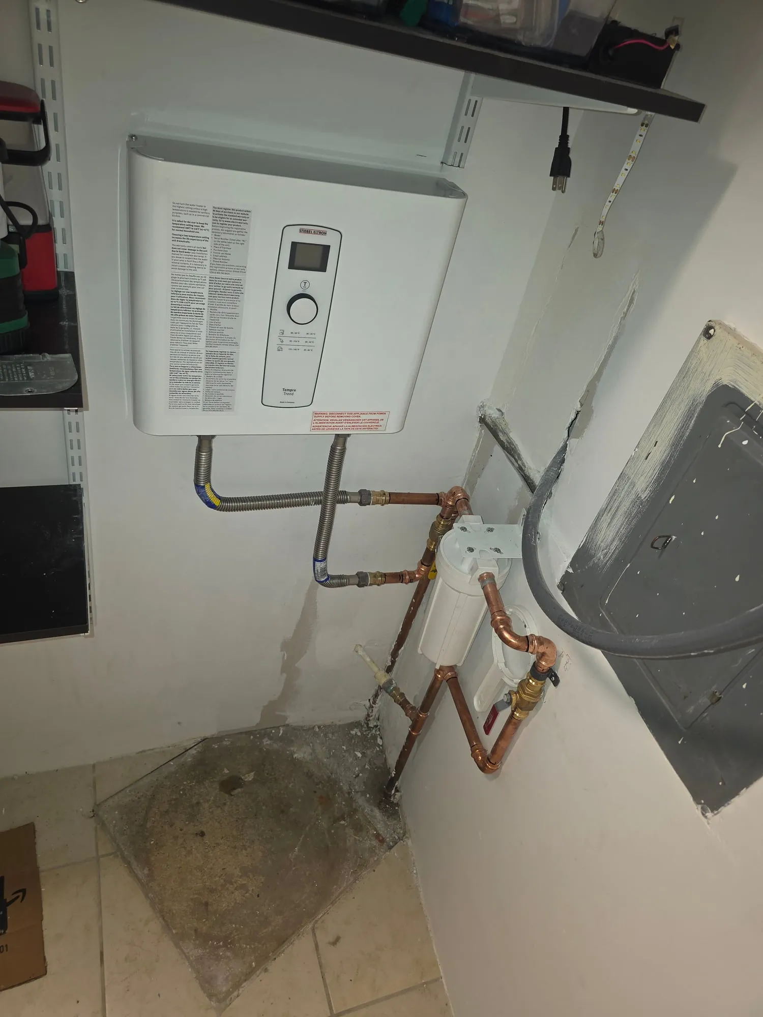Electric tankless water heater installed in a laundry room
