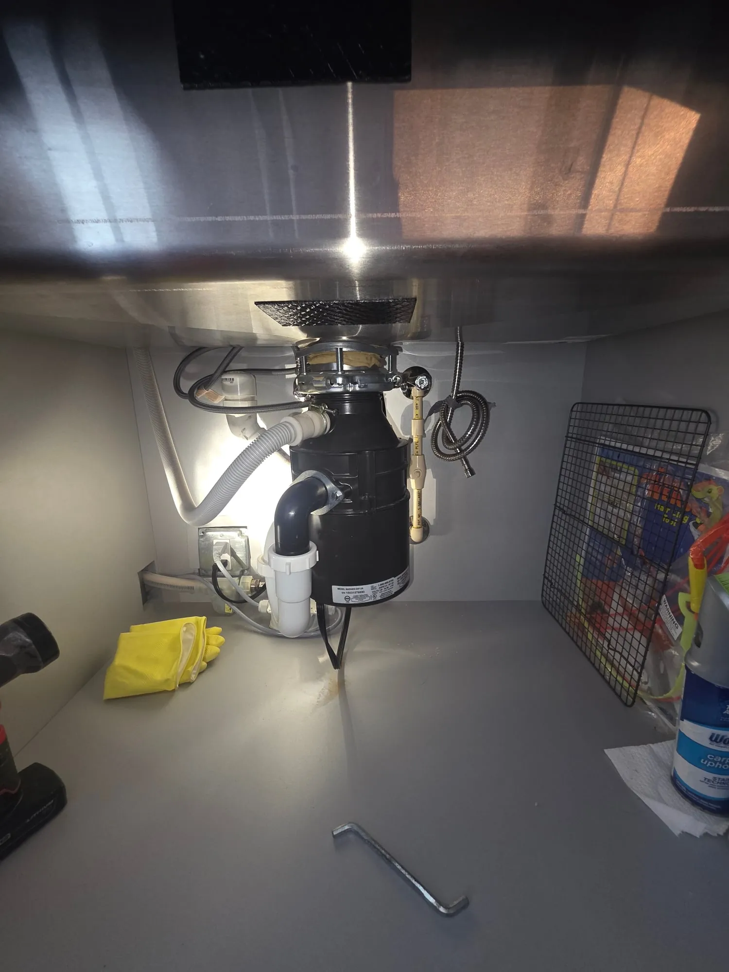 New garbage disposal installed under a kitchen sink