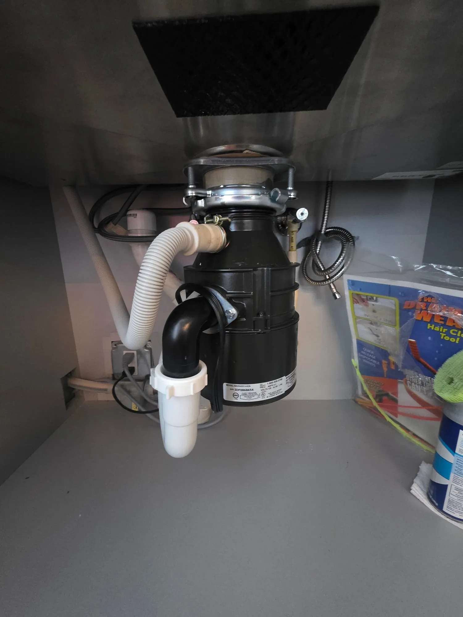 Close-up of a newly installed garbage disposal and drain connections