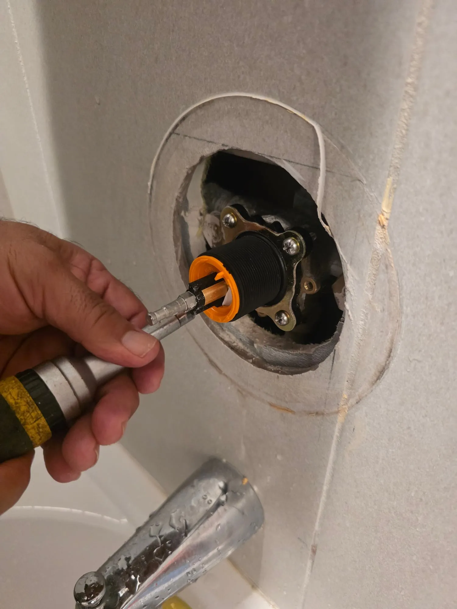 Plumber installing a new cartridge in a tub and shower valve