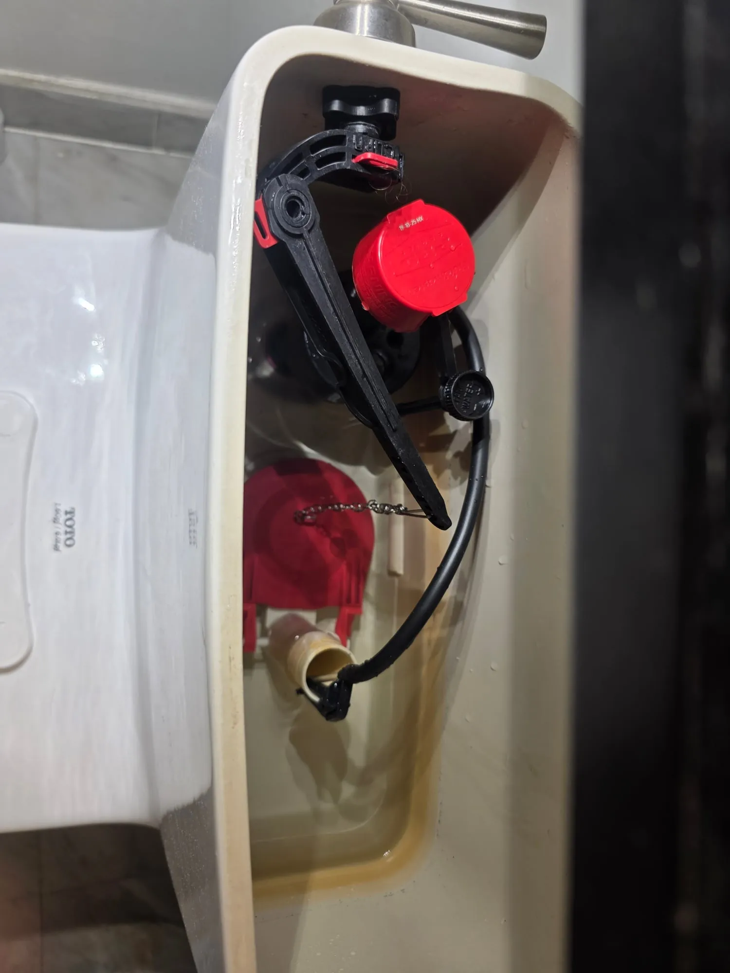 Toilet tank with a new flush valve and fill valve installed